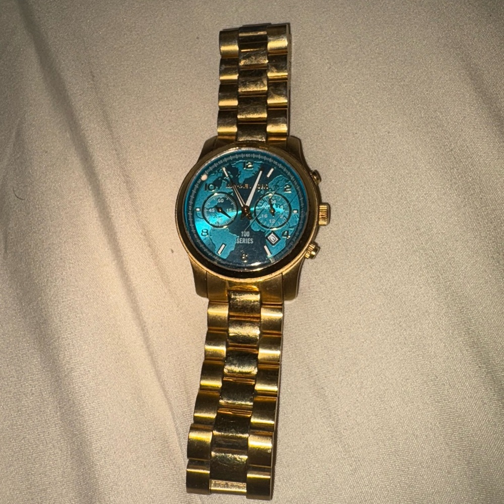 Michael Kors “WATCH HUNGER STOP” Gold Watch with Blue Dial